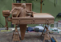 Lifesize carving of a wooden coffin which is also a boat
